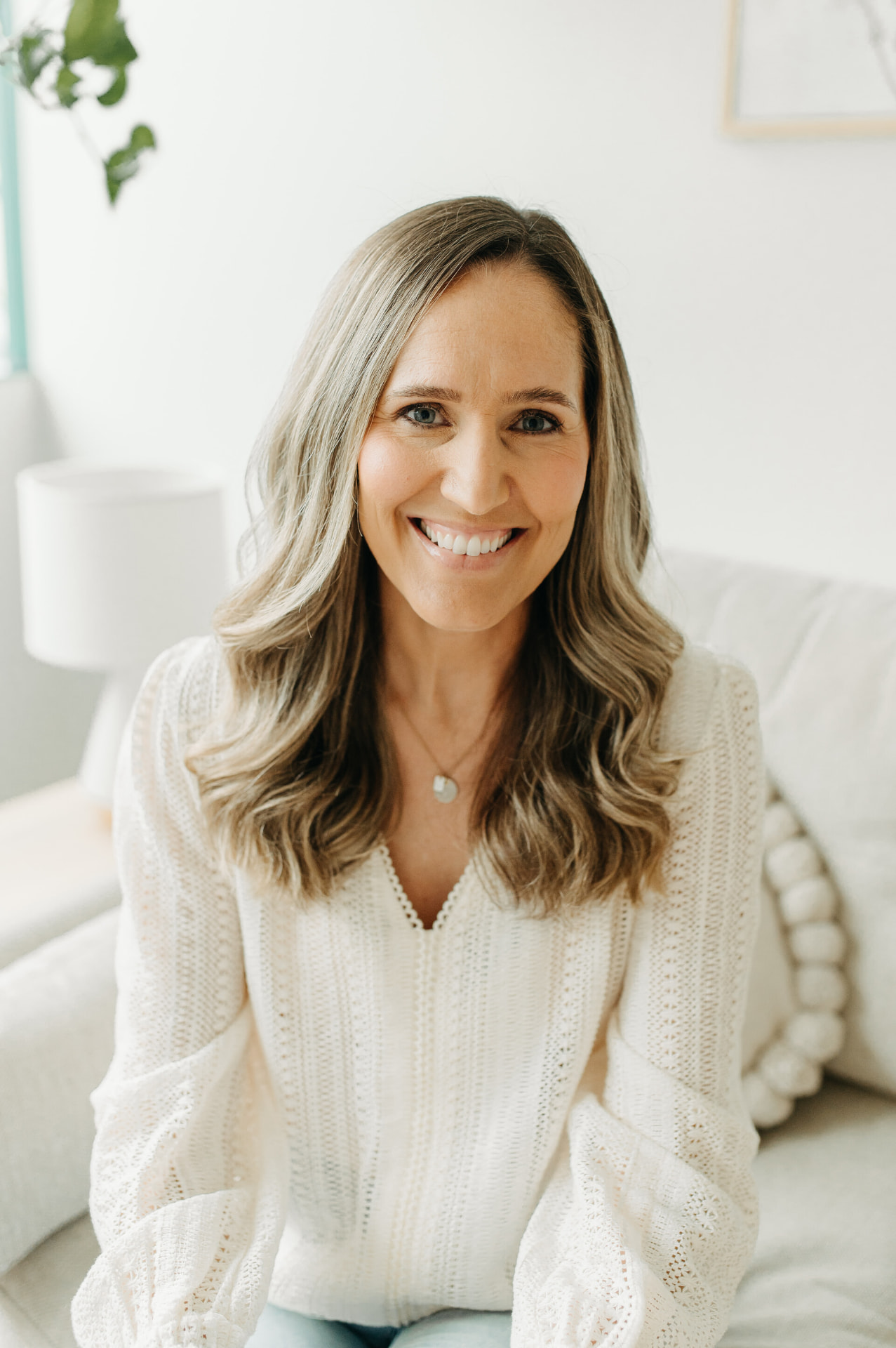 Dr. Kelly Vincent, Psy.D., smiling in a cream sweater